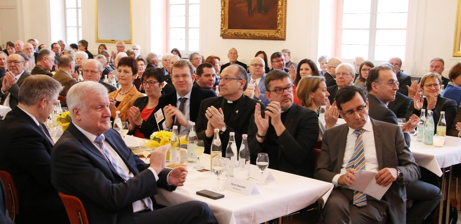 Im vollbesetzten Spiegelsaal sitzt eine große Festgemeinde und hört aufmerksam einem Vortrag zu.