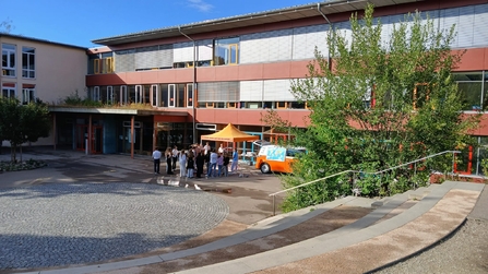 Schüler im Schulhof diskutieren beim Klimamobil